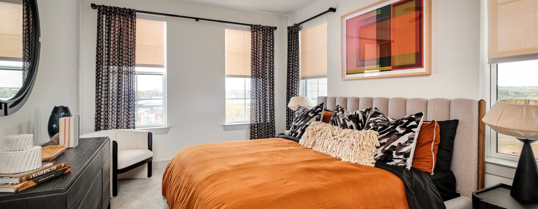 bedtoom with bed and dresser with ample windows 